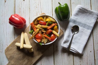 Tabakta sote sebze ve et ve ahşap kesim tahtasındaki baharatlarla birlikte.