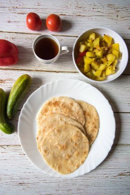 Popüler Hint kahvaltısı puri ve sabzi 'nin dikey görüntüsü ve bir fincan çay..