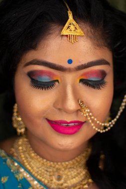 Hintli bir kız resepsiyon partisi makyajını gösteriyor.