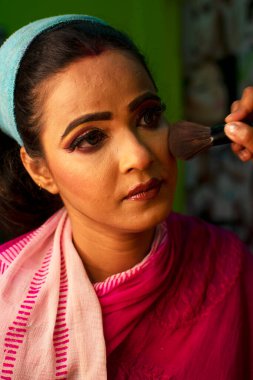 Güzellik salonunda makyaj yaptıran Hintli bir kadın.