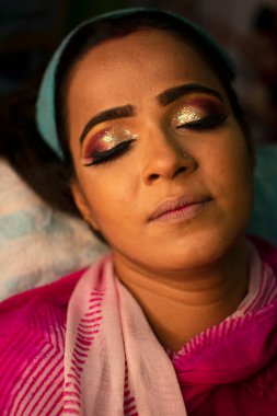 Güzellik salonunda göz makyajı yaptıran Hintli bir kadın.