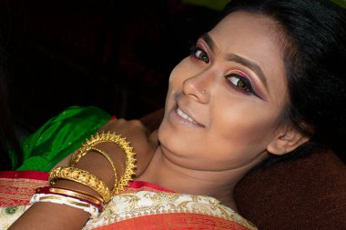 Hintli bir kadın gelin makyajı yaptırıyor.