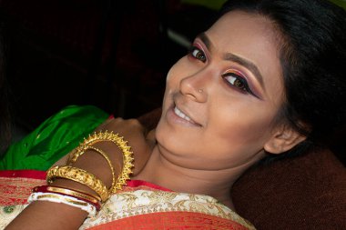 Hintli bir kadın gelin makyajı yaptırıyor.