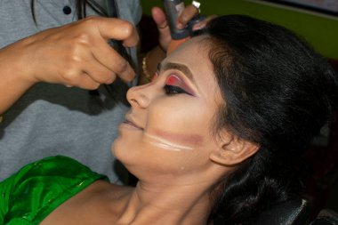 Hintli bir kadın gelin makyajı yaptırıyor.