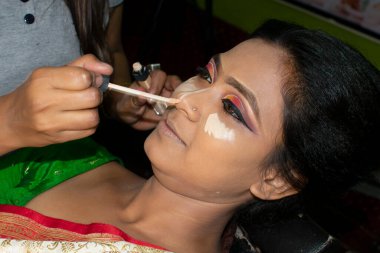 Hintli bir kadın gelin makyajı yaptırıyor.