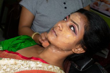 Hintli bir kadın gelin makyajı yaptırıyor.