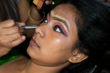 Hintli bir kadın gelin makyajı yaptırıyor.