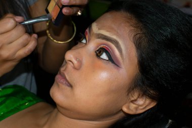 Hintli bir kadın gelin makyajı yaptırıyor.