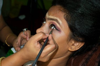 Hintli bir kadın gelin makyajı yaptırıyor.