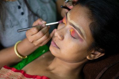 Hintli bir kadın gelin makyajı yaptırıyor.