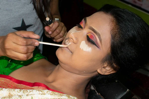 Hintli bir kadın gelin makyajı yaptırıyor.