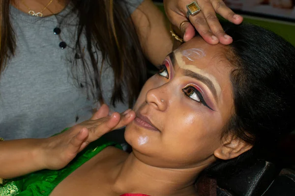 Hintli bir kadın gelin makyajı yaptırıyor.