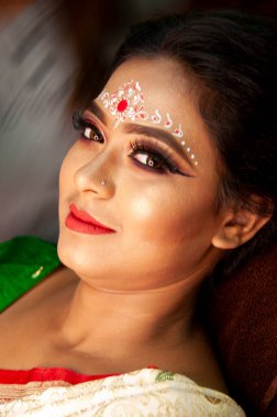 Hintli bir kadın gelin makyajı yaptırıyor.