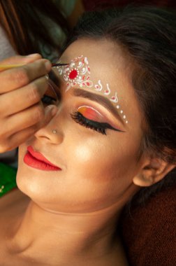 Hintli bir kadın gelin makyajı yaptırıyor.