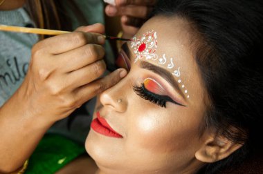 Hintli bir kadın gelin makyajı yaptırıyor.