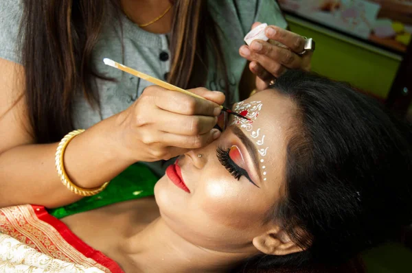 Hintli bir kadın gelin makyajı yaptırıyor.