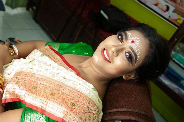 Hintli bir kadın gelin makyajı yaptırıyor.