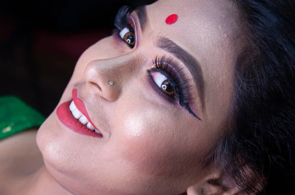 Hintli bir kadın gelin makyajı yaptırıyor.