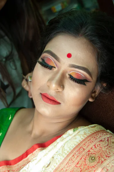 Hintli bir kadın gelin makyajı yaptırıyor.