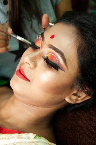 Hintli bir kadın gelin makyajı yaptırıyor.