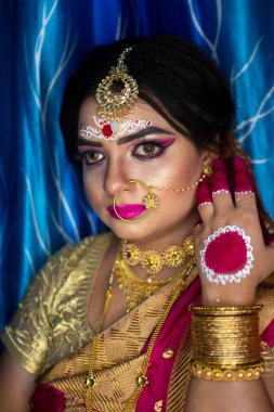 Gelin 'deki şirin bir Hint modelinin portresi. Ağır altın mücevher ve kırmızı sari ile.