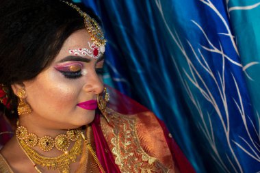 Gelin 'deki şirin bir Hint modelinin portresi. Ağır altın mücevher ve kırmızı sari ile.