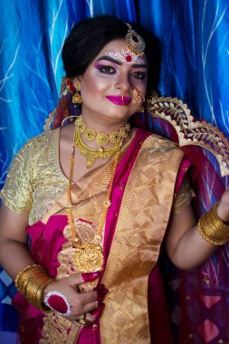Gelin 'deki şirin bir Hint modelinin portresi. Ağır altın mücevher ve kırmızı sari ile.