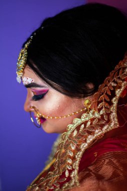 Hint gelini, Hindu kırmızı geleneksel düğün kıyafetleri içinde altın takı işlemeli sari.