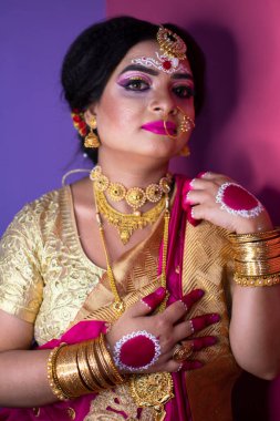 Hint gelini, Hindu kırmızı geleneksel düğün kıyafetleri içinde altın takı işlemeli sari.