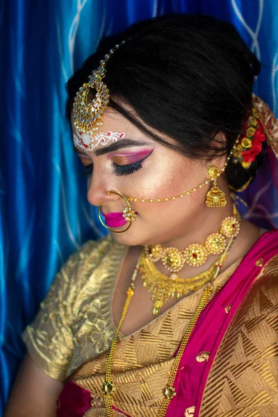 Gelin 'deki şirin bir Hint modelinin portresi. Ağır altın mücevher ve kırmızı sari ile.
