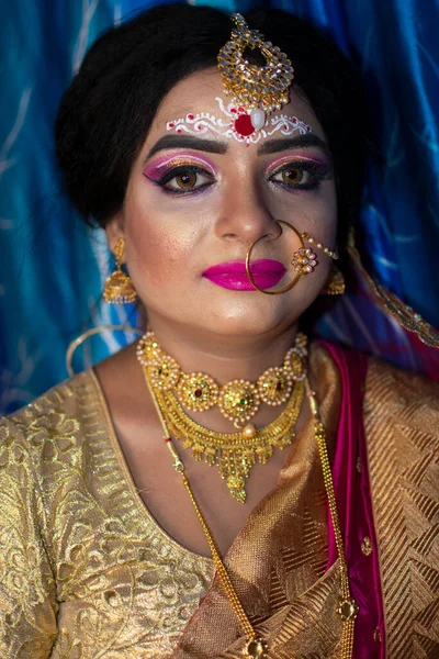 重い金の宝石や赤サリとブライダルルックでかわいいインドのモデルの肖像画 — ストック写真