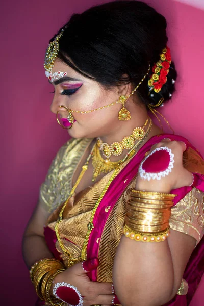 bridal portrait of indian lady wearing traditional saree and gold jewellery
