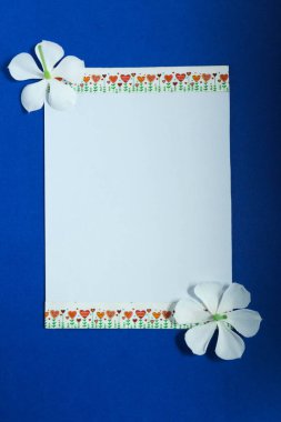 Çiçekler ve bitkilerle dolu boş beyaz maket kartı.