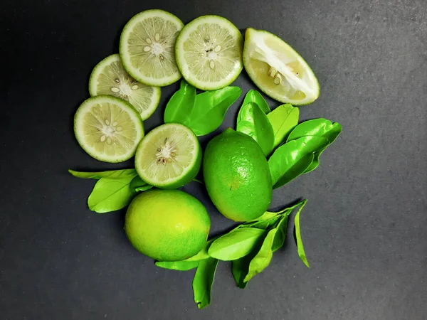 黒を基調としたジューシーなレモン レモンスライス 緑の葉 — ストック写真