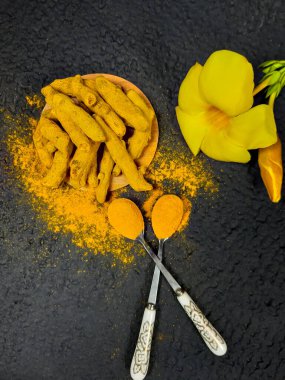 Siyah arka planda sarı çiçekli zerdeçal (Curcuma longa). Romatoid artrit ve antioksidan aktivitelerinde bitkisel ilaç olarak kullanılır..