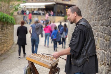 Beynac, Dordogne, Fransa; 21 04 2019: Beynac kalesinin yanındaki mezmur çalan Ortaçağ sokak müzisyeni