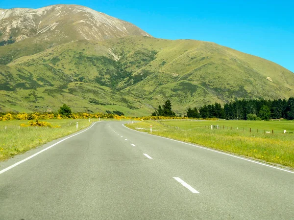 stock image road to mountain (in front of) with blue sky