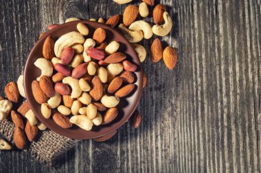 Tahta masadaki fındıklı kasede karışık fındık, fotokopi alanı ile üst manzara