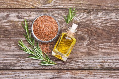 Şişedeki keten tohumu yağı, keten tohumu, ahşap sırtta biberiye filizi.