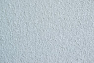 Soyut lekeleri ve pürüzsüz dokusu olan beyaz beton yüzey.