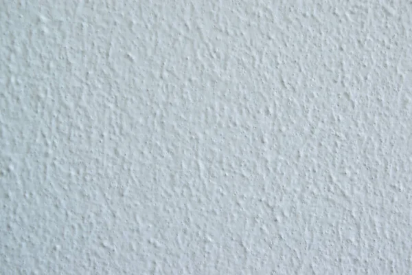 Soyut lekeleri ve pürüzsüz dokusu olan beyaz beton yüzey.