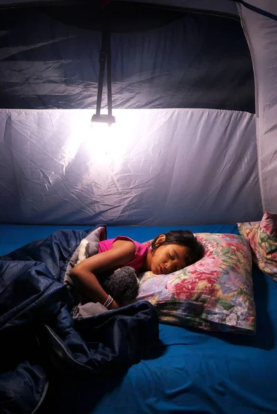 Menina Metis dormindo profundamente em uma barraca de acampamento durante as férias. Fotografias De Stock Royalty-Free