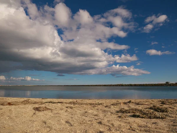 Photo big thick clouds in the sky above a pond — Stock Photo, Image