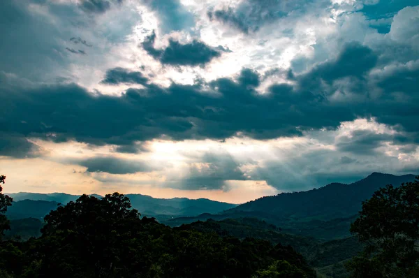 Tayland 'ın Phang Nga Körfezi yakınlarındaki yağmurdan sonra kara bulutlarda güneş ışınları parlıyor.