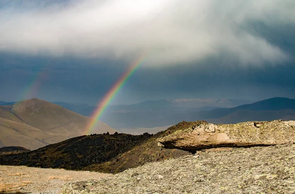 Rusya, Kabardino-Balkaria 'da bulutlu bir günde Elbrus yakınlarındaki dağlarda iki gökkuşağı.