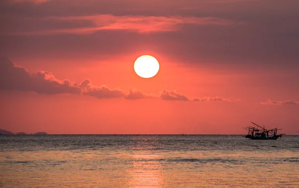 Phuket, Tayland 'da kırmızı günbatımının arka planında bir balıkçı teknesi
