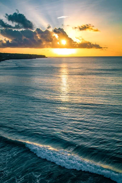 Okyanusta güzel sarı gün batımı. Endonezya, Bali yakınlarında bulutlu bir gökyüzünde.