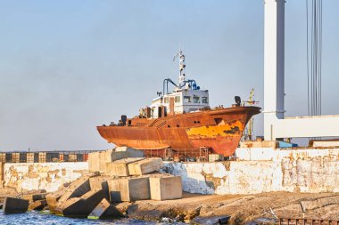 Kıyıda tamir için terk edilmiş eski bir gemi var.