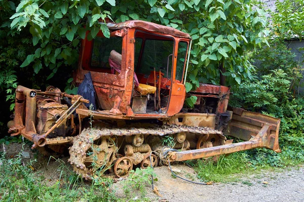 Stary zardzewiały sowiecki traktor, stojący na trawie — Zdjęcie stockowe