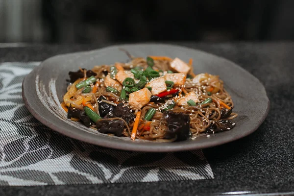 Restoranda hazır yemek, sağlıklı malzemeler, balık, domates, susamlı şehriye, geleneksel Asya mutfağı.